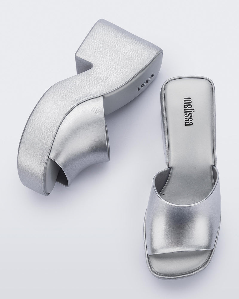 Top and side view of a pair of Melissa Posh platform slides in Silver