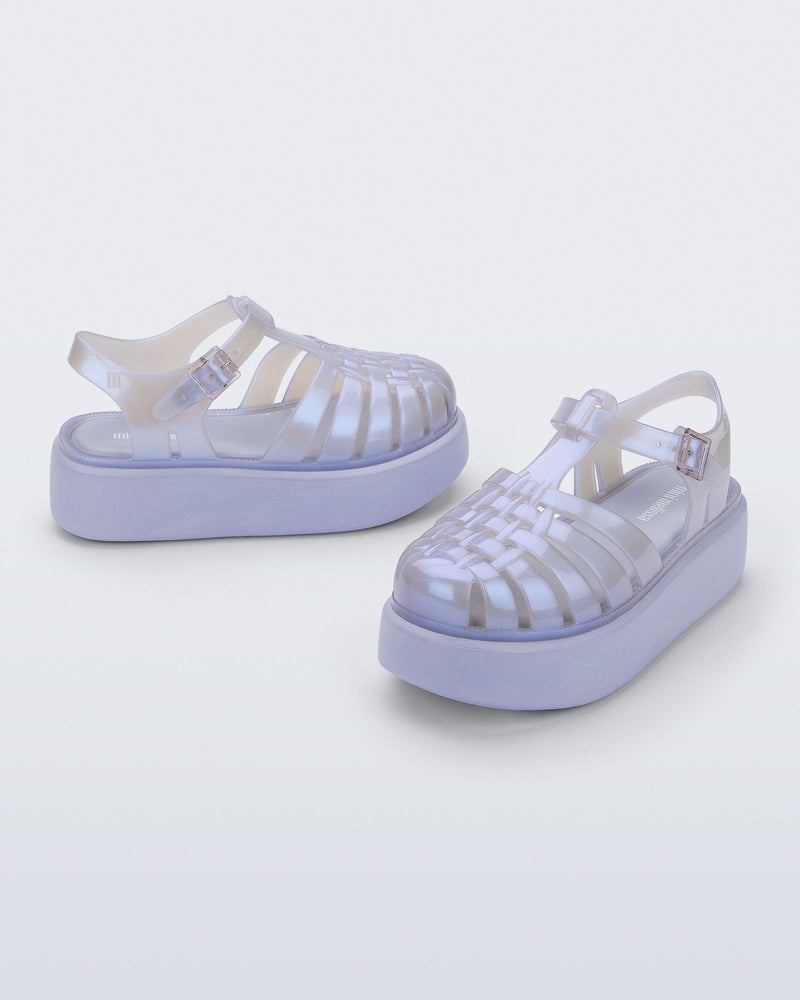 Back and angled view of a pair of pearly blue Possession Platform kids fisherman sandals with lilac soles