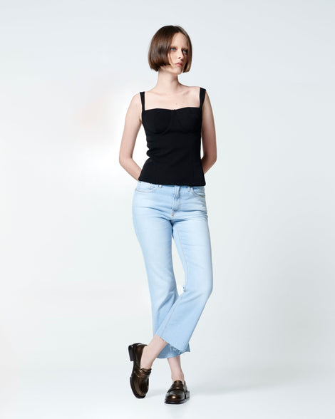 Model in black tank top and ankle jeans wearing a pair of bronze Spencer loafers