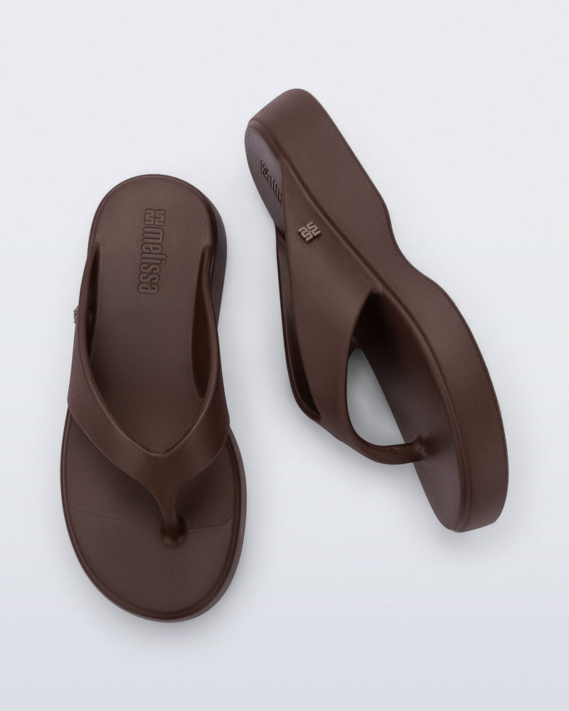 Top and side view of a pair of bronze Free Thong Low Flip Flops