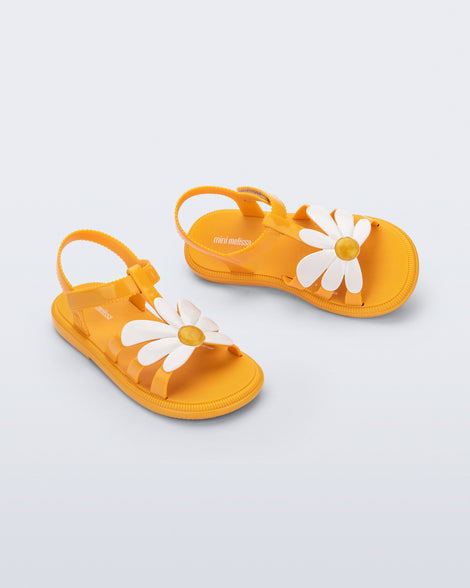 top and angled view of a pair of orange Hip Bloom kids sandals