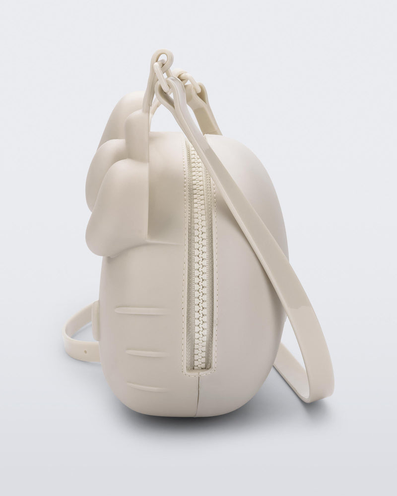 Side view of a beige Hello Kitty + Friends Cute Bag with the face of Hello Kitty