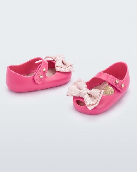 Angled view of a pair of pink My First Melissa mary jane with a pink bow.
