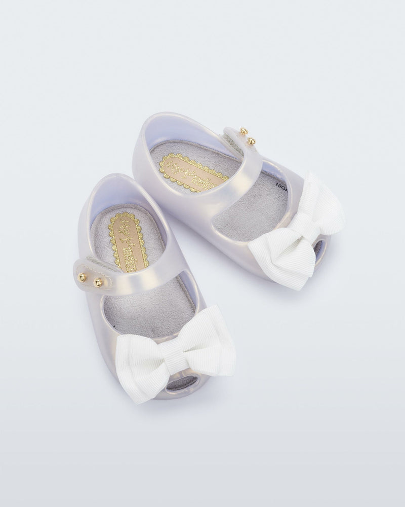Top view of a pair of pearly white My First Melissa mary jane with a bow.