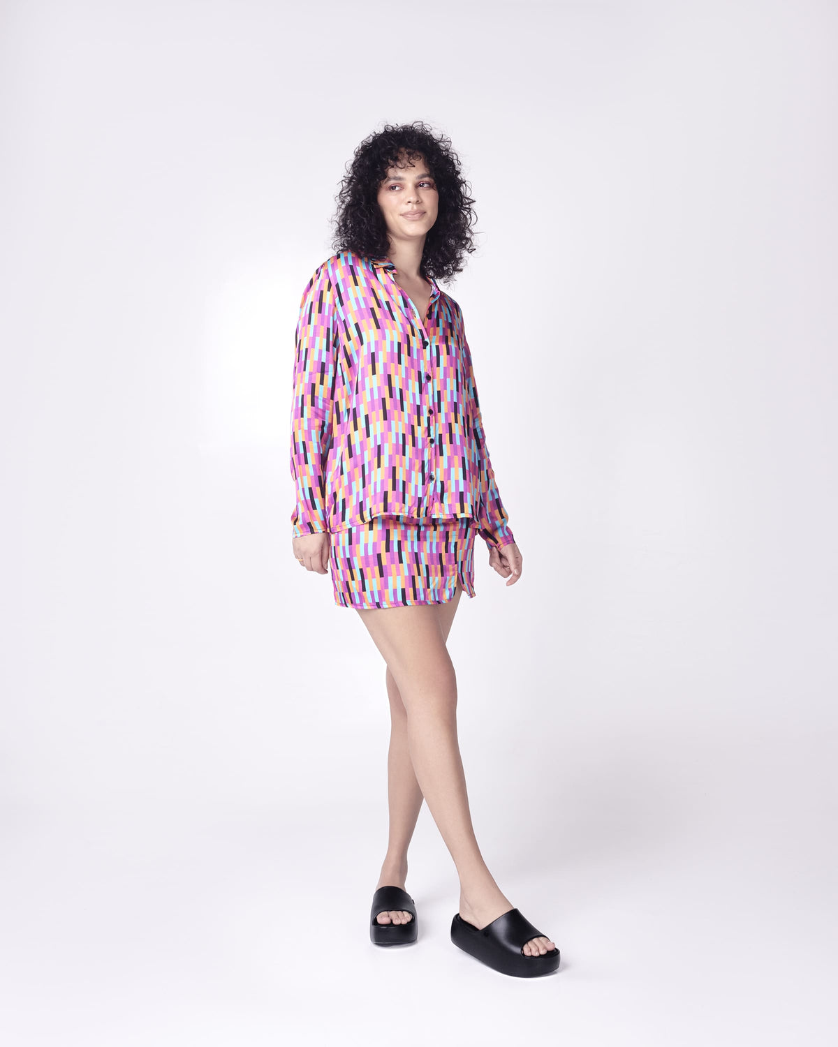 Model in multi colored outfit wearing a pair of black Free Platform women's Slides