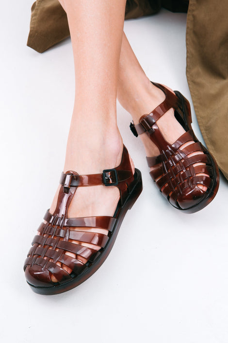Model's feet wearing a pair of clear brown Possession fisherman sandals
