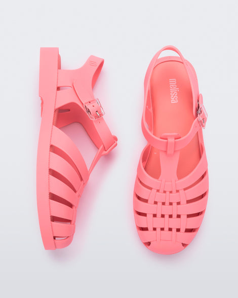 Top and side view of a pair of coral pink Melissa Possesion sandal.