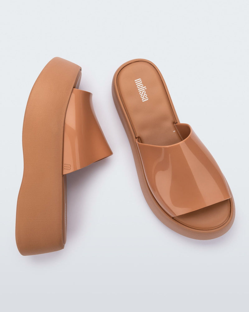 Top and side view of a pair of Melissa Becky platform slides in beige