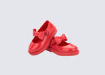 Angled view of a pair of red Blair baby mary janes with bow in the strap