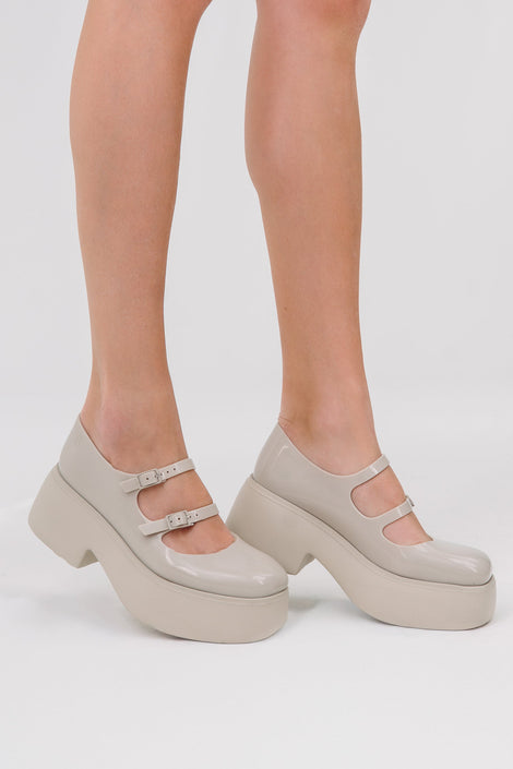 Model's legs wearing a pair of beige Farrah platform mary janes