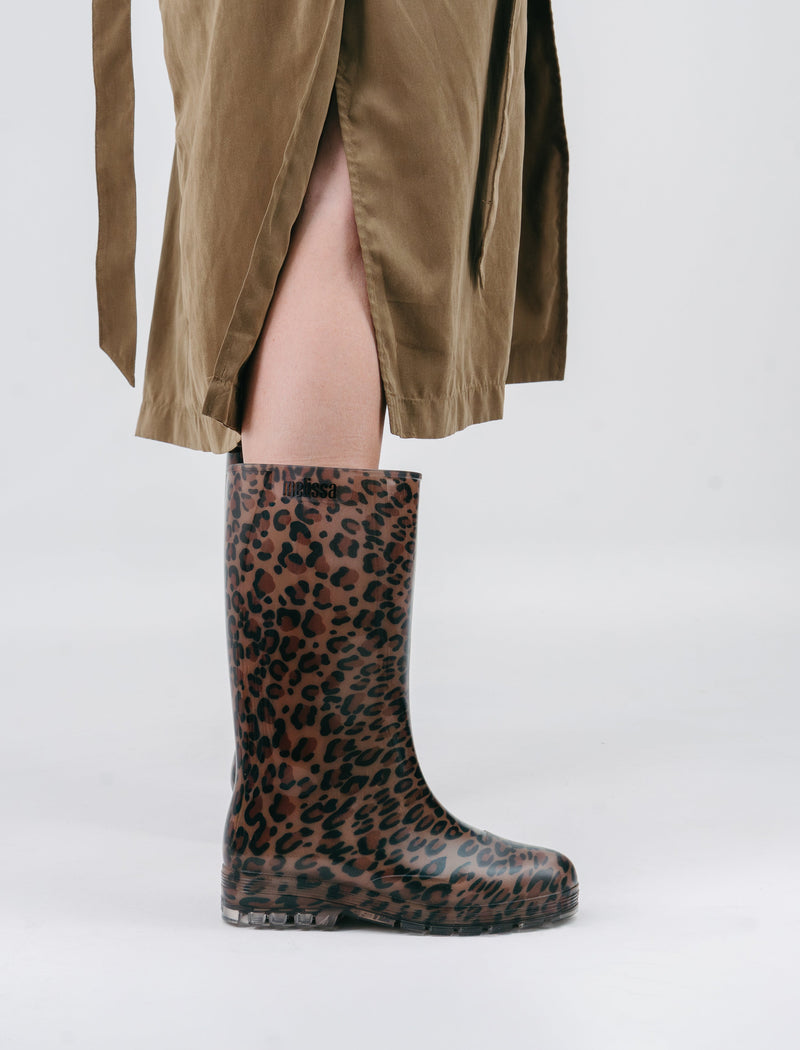 Model's legs in a brown skirt wearing a pair of brown/black leopard print Welly rain boots