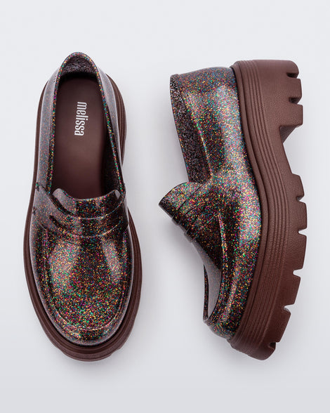 Top and side view of a pair of Melissa Royal loafers in glitter multicolor with a brown platform sole.