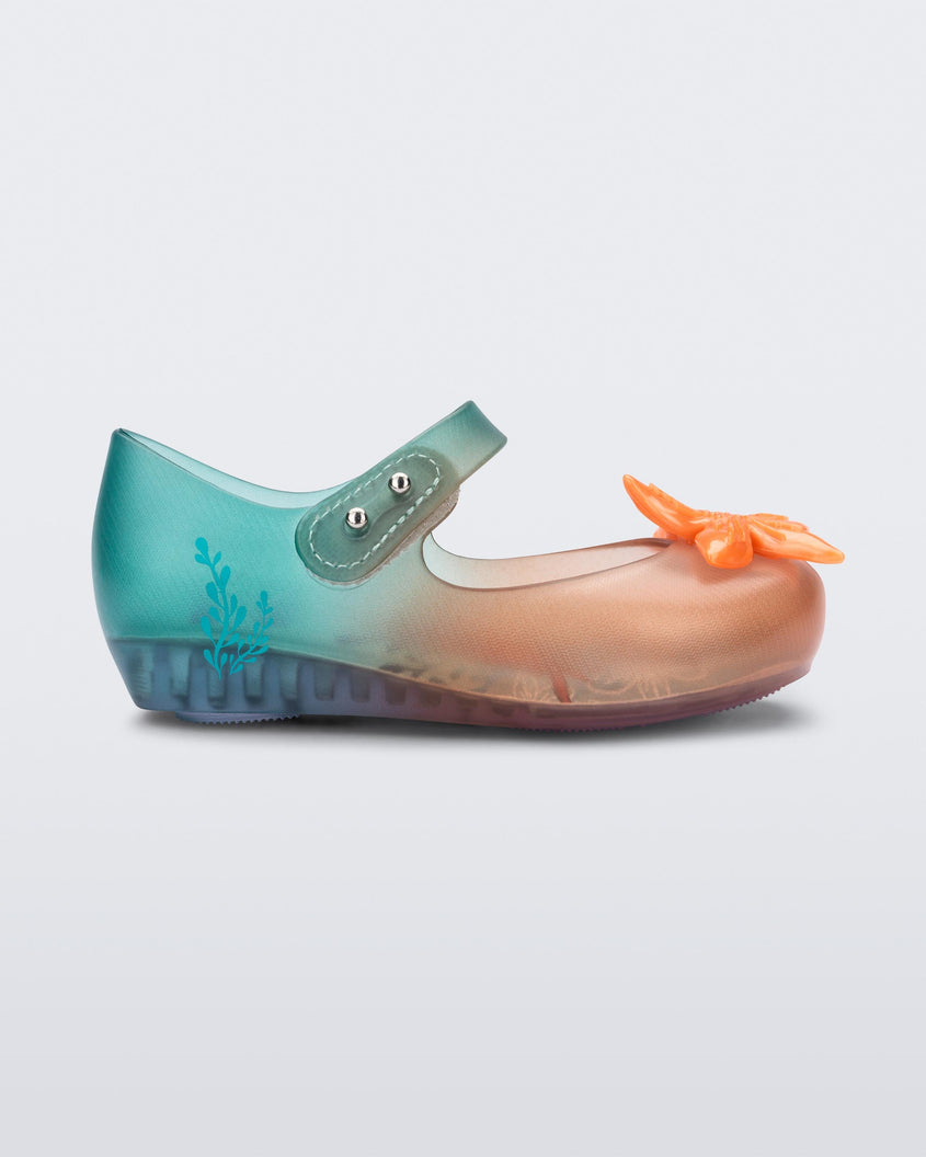 Side view of a transparent green and orange Mini Melissa Ultragirl + Disney Little Mermaid flat with a pearly orange flower on top