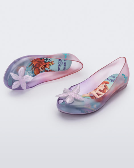 Top and angled view of a pair of clear pearly pink and purple Mini Melissa Ultragirl + Disney Little Mermaid flats with a pearly purple flower.
