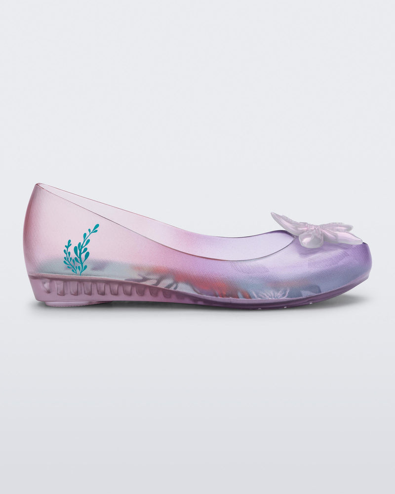 Side view of a clear pearly pink and purple Mini Melissa Ultragirl + Disney Little Mermaid flat with a pearly purple flower.