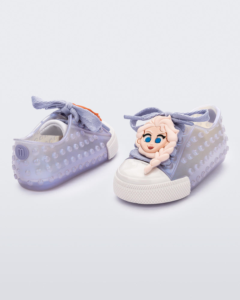 Angled view of a pair of baby metallic blue Melissa Polibolha Disney sneakers with a white toe top with Disney Frozen's Anna and Elsa.