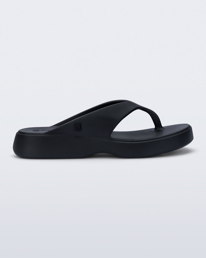 Side view of a black Free Thong Low flip flop