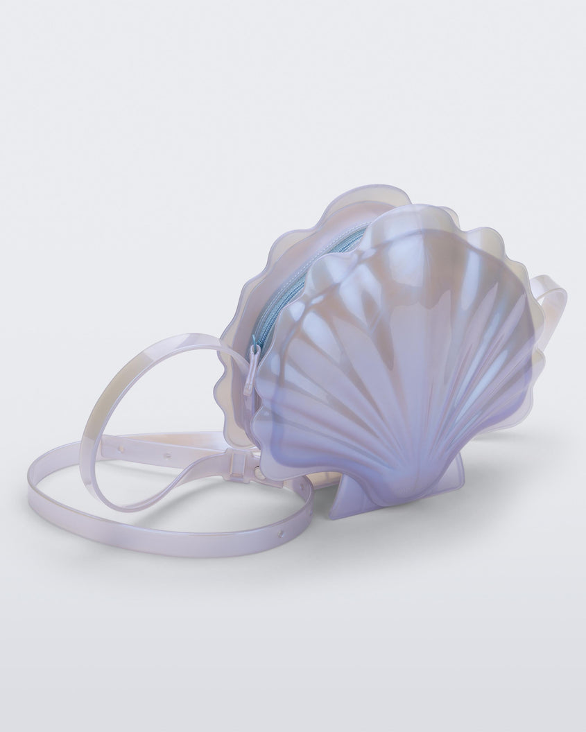 Angled view of a pearly blue Melissa Shell + Disney Little Mermaid bag with strap.