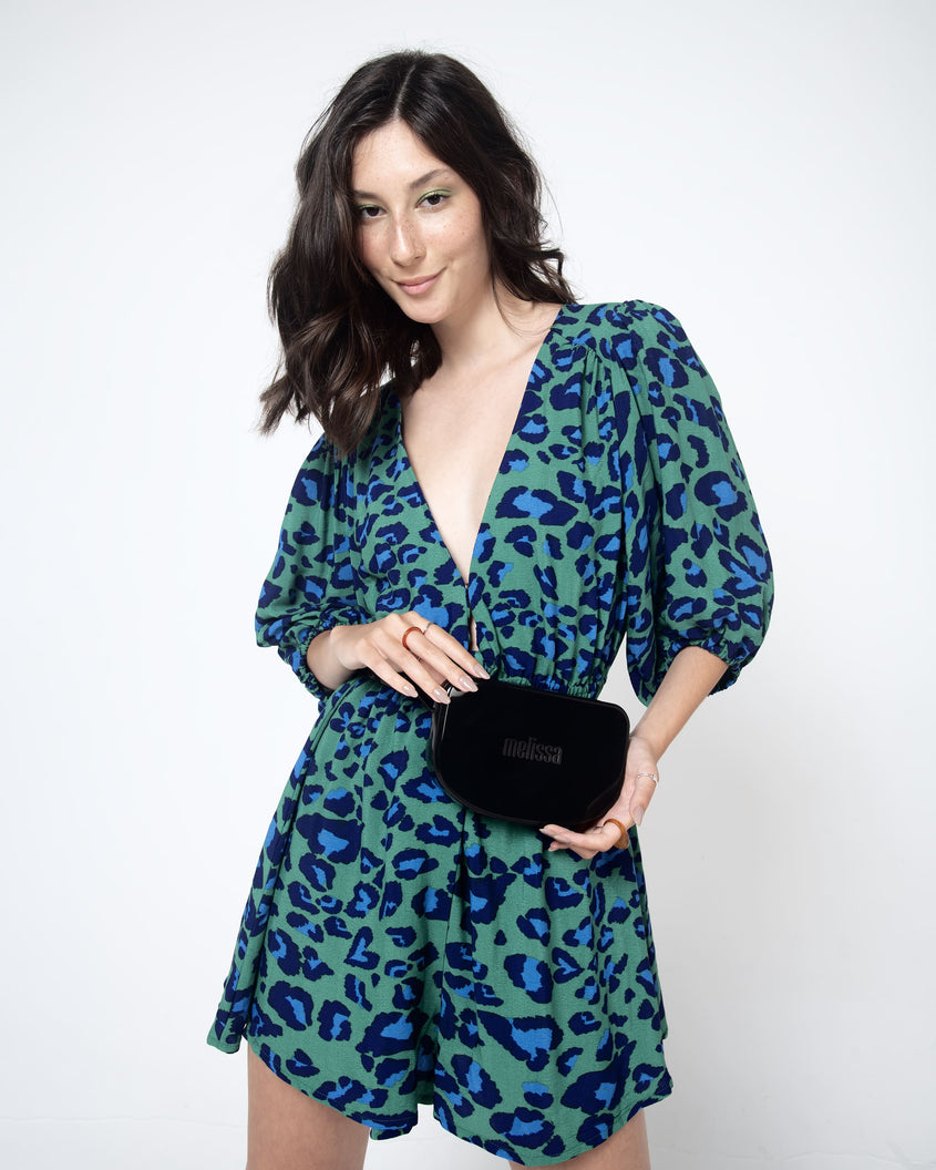 Model wearing a patterned dress and holding the black Melissa Go Easy bag.