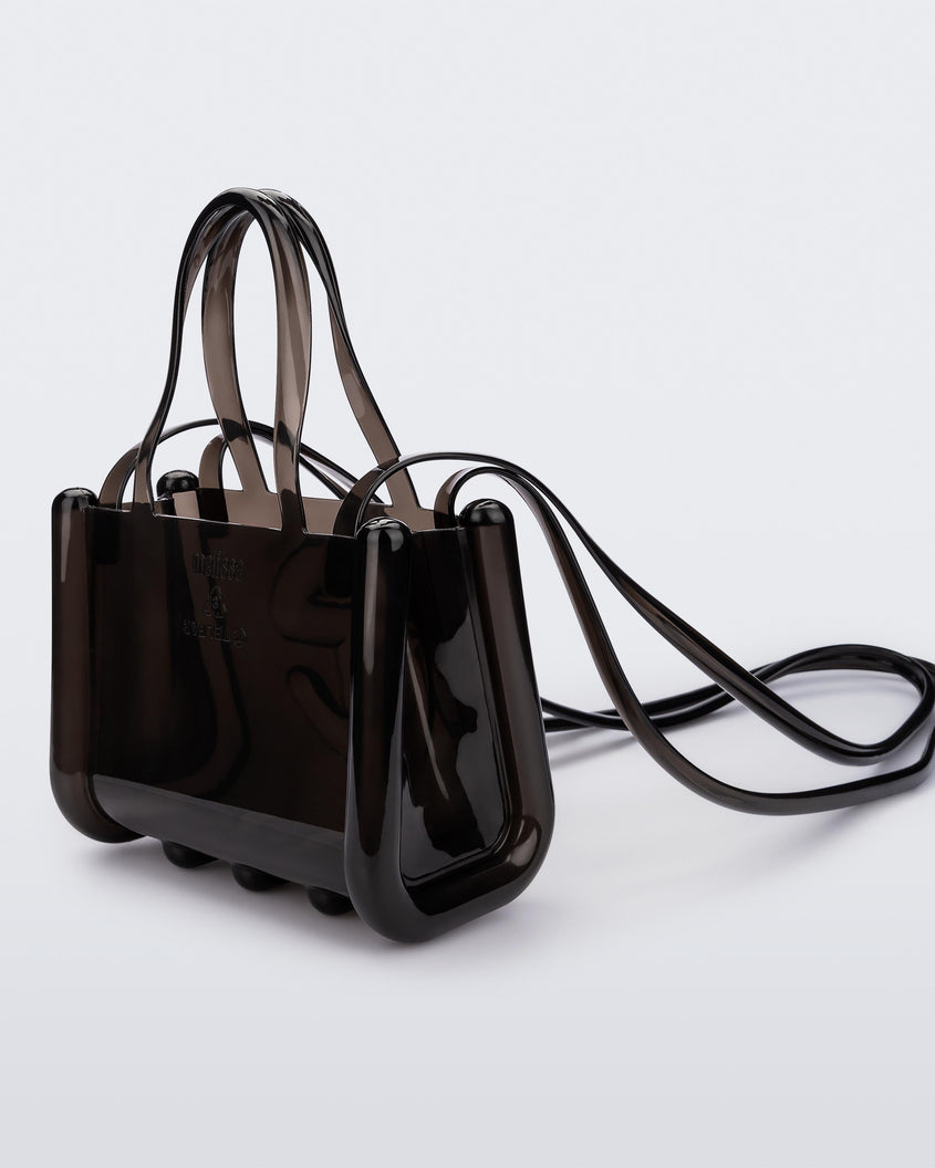 Angled view of a black small Melissa Jelly Shopper bag + Telfar bag with a handle and straps.
