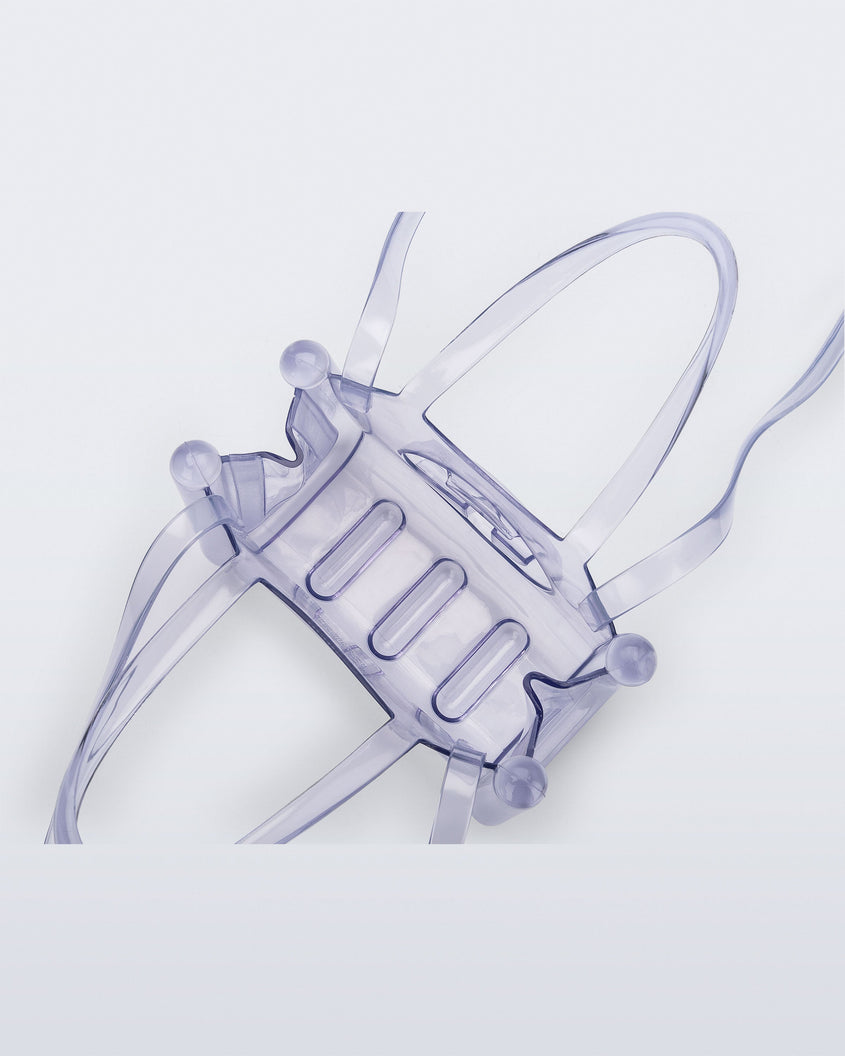 Top view of a clear Melissa Small Jelly Shopper + Telfar bag with handles and a body strap