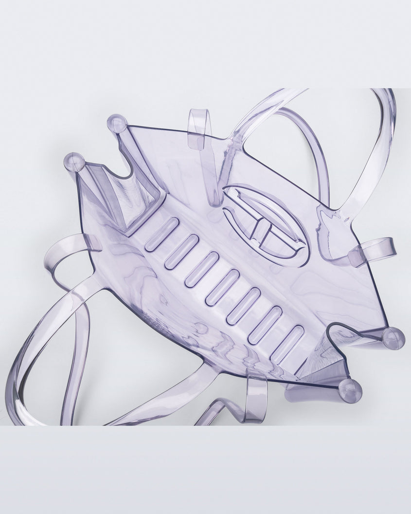 Top view of a clear Melissa Large Jelly Shopper + Telfar bag with handles and a body strap