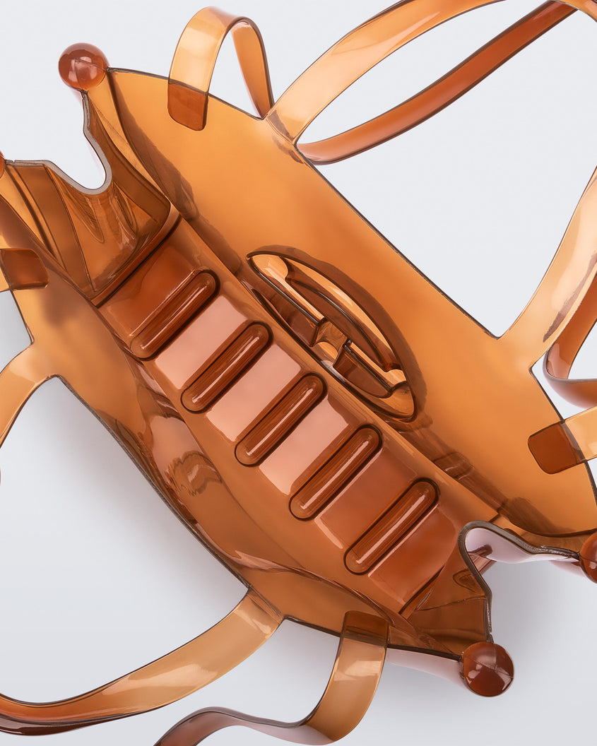 Top view of a brown medium Melissa Jelly Shopper bag + Telfar bag with a handle and straps.