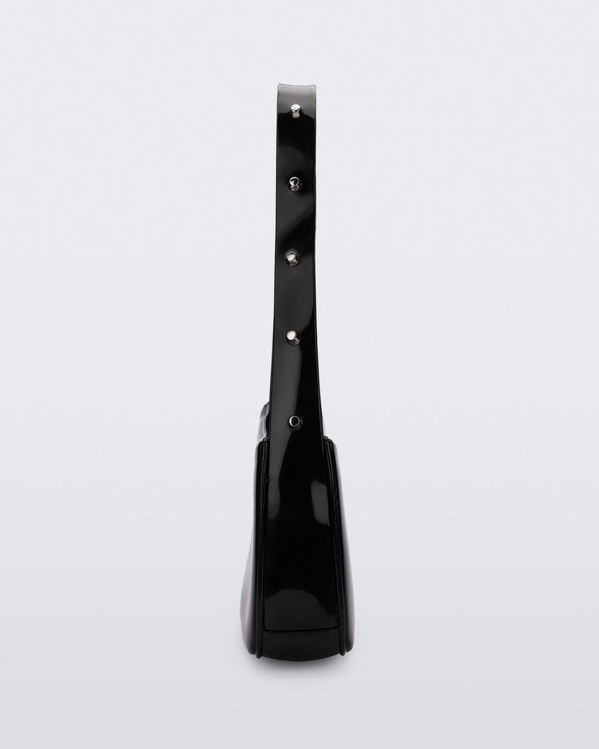 Side view of the black Melissa Baguete Studs bag with a short studded strap.