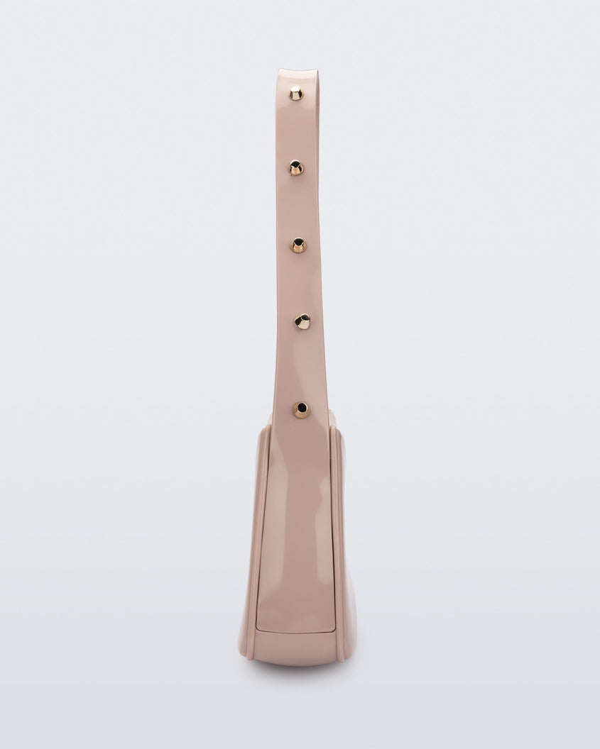 Side view of the pink Melissa Baguete Studs bag with a short studded strap.