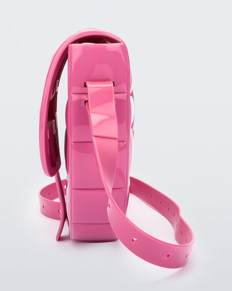 Side view of a pink Possession Bag with strap.
