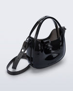 Angled view of a clear black Mirror bag with cross body straps two clear handles.