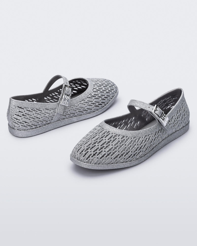 Top and angled view of a pair of silver glitter Harper flat with strap