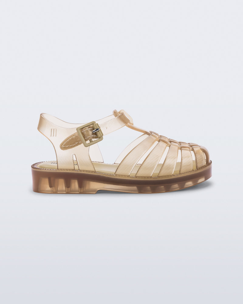 Side view of a clear beige Possession baby sandal