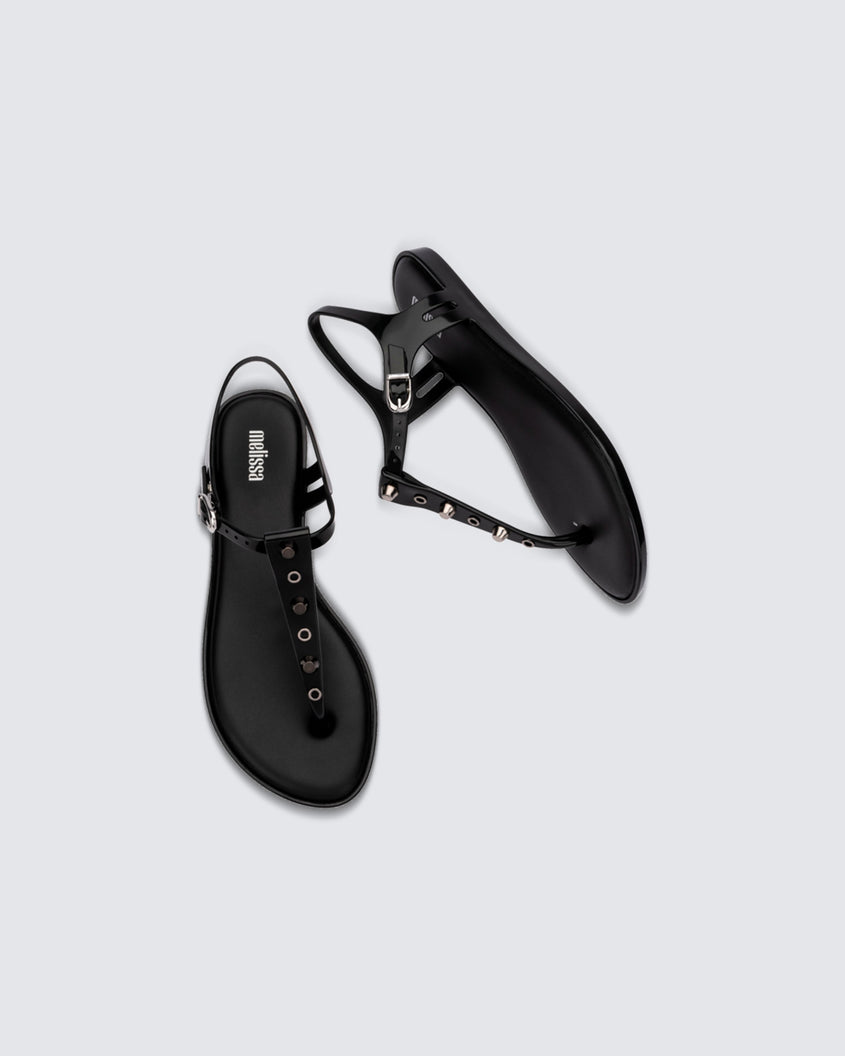 Top and side view of a pair of black Melissa Solar studs sandals with gold studded t-strap and gold buckle.
