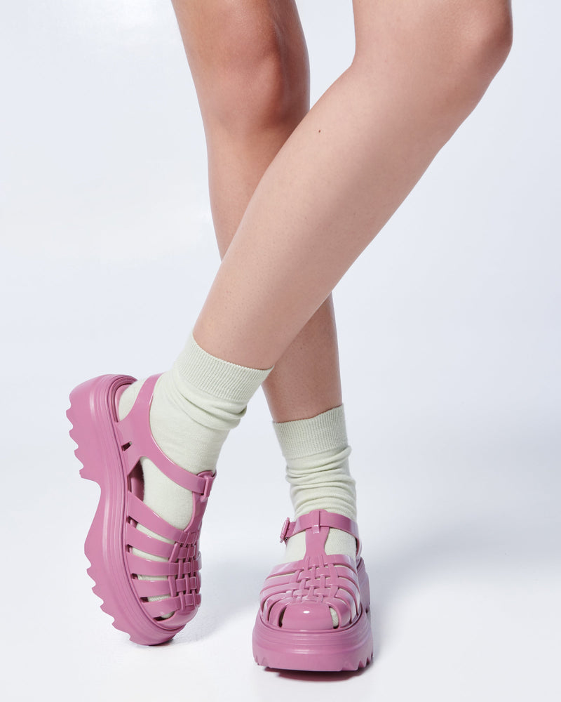 Model's legs in white socks wearing a pair of lilac Possession Platform II fisherman sandals