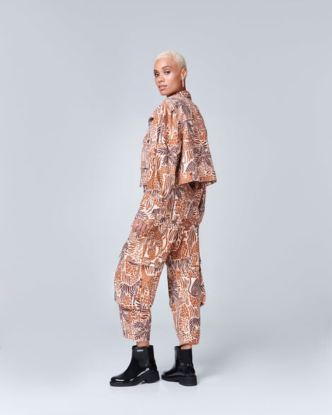 Model in a patterned pant suit wearing a pair of black Chelsea Boots.