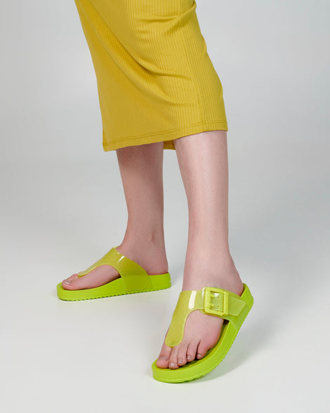 Model's legs wearing a pair of green Cozy Flip flops