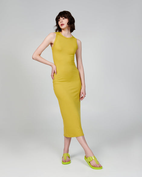 Model in a green dress wearing a pair of green Cozy Flip flops