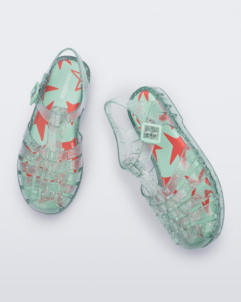 Top angled view of a pair of clear green star glitter Possession kids fisherman sandals
