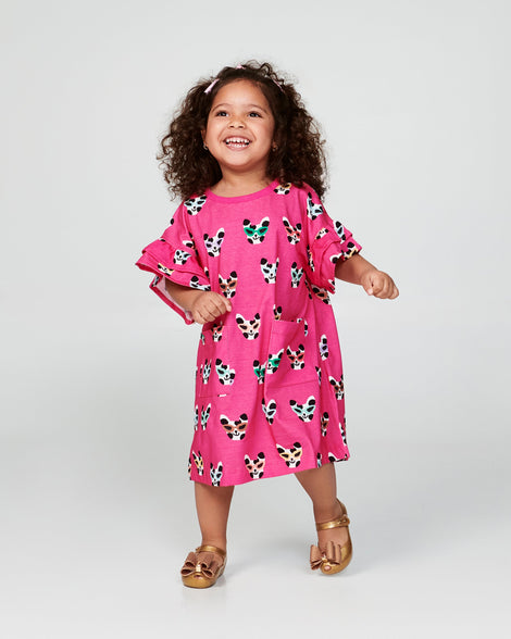 Child model in a pink dress wearing a pair of pearly beige baby Ultragirl Classic Bow