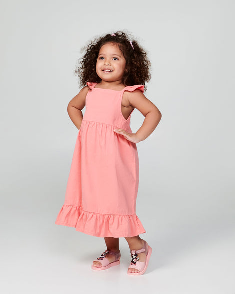 Child model in a coral dress wearing a pair of pink Play Mickey & Minnie sandals