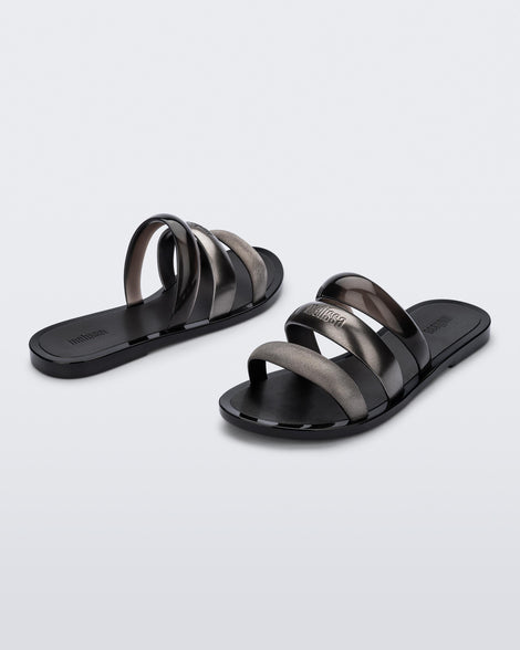 Back and angled view of a pair of black Eclipse Slides with gold and black straps.