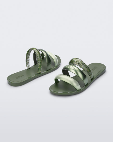 Back and angled view of a pair of green Eclipse Slides with glitter green straps.