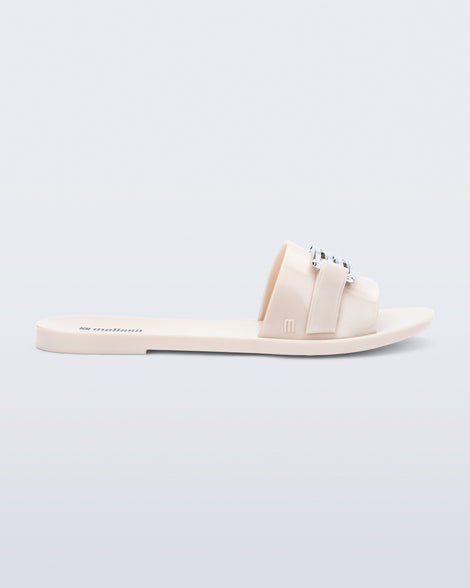 Side view of a beige Babe M Chic slide sandal