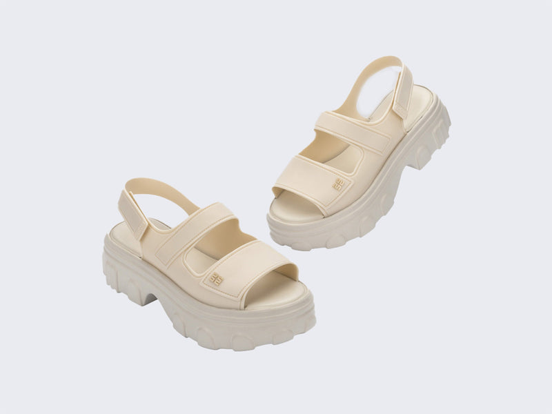 Angled view of a pair of beige Ella Move Sandals