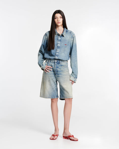 Model in jean shorts and jean button down shirt wearing a pair of transparent red Flip Flop + Diesel sandals