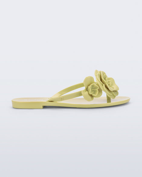 Side view of a green Harmonic Petals flip Flop with green flowers on top