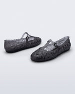 Back and side angled view of a pair of clear black Melissa + Susan Fang Daphnis Ballerinas with t-top strap