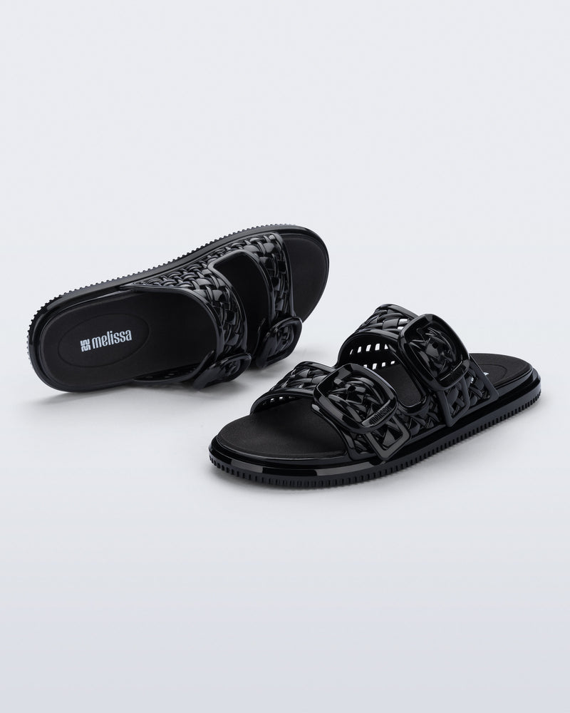 Top and side view of a pair of black Possession Slip sandals with two straps with buckles