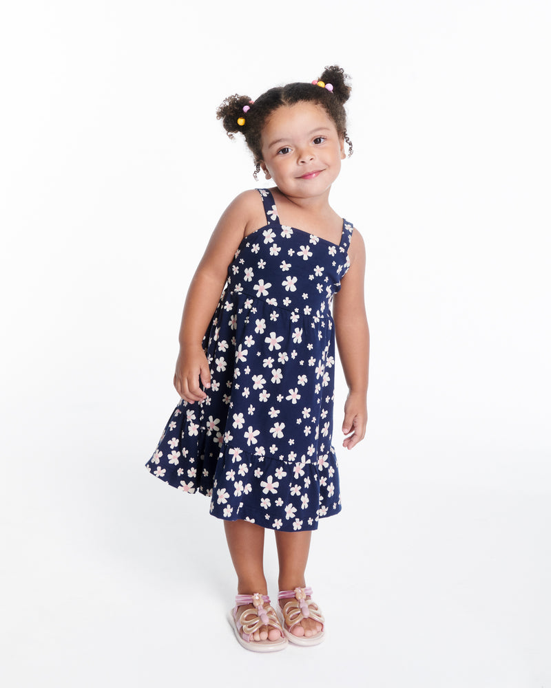Child model in a blue dress wearing a pair of pink strap, beige sole Hip Butterfly baby sandals